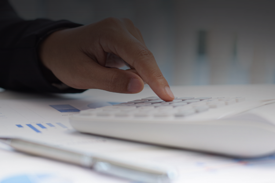 A white calculator being used for calculations. Representing VAT registration in South Africa
